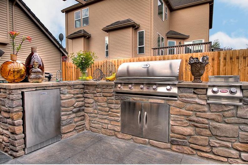 Outdoor kitchen with stone countertop and BBQ area